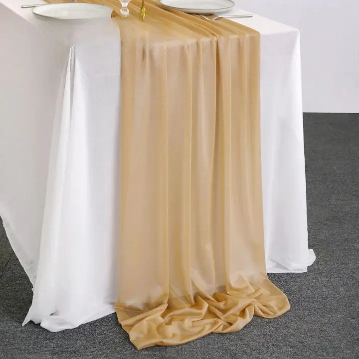Chemin de table en organza beige doré posé sur table blanche pour décoration élégante