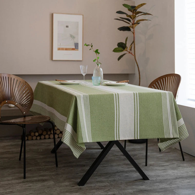 Nappe verte à rayures claires installée sur une table de salle à manger style naturel et épuré