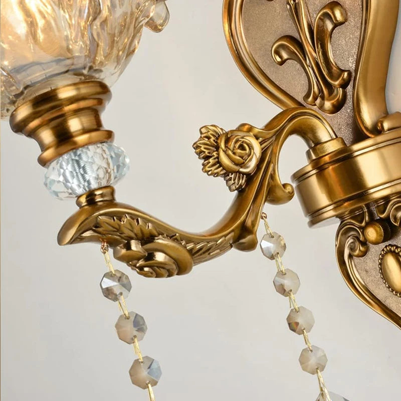 Détail du bras sculpté en laiton avec pampilles en cristal d’une applique murale classique