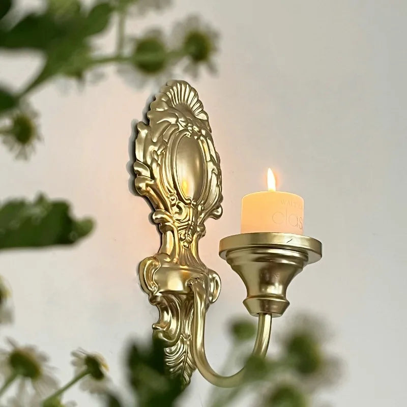 Détail d’une applique murale baroque dorée avec porte-bougie, finition classique