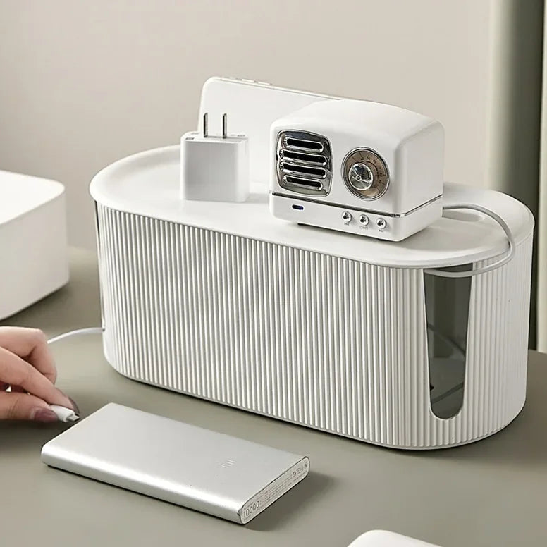 Boite de rangement multiprise blanche avec chargeur et accessoires posés sur un bureau moderne