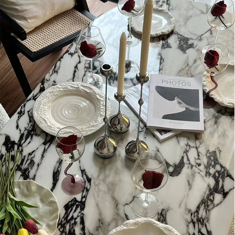 Bougeoirs décoratifs en métal argenté utilisés comme centre de table lors d’un repas.