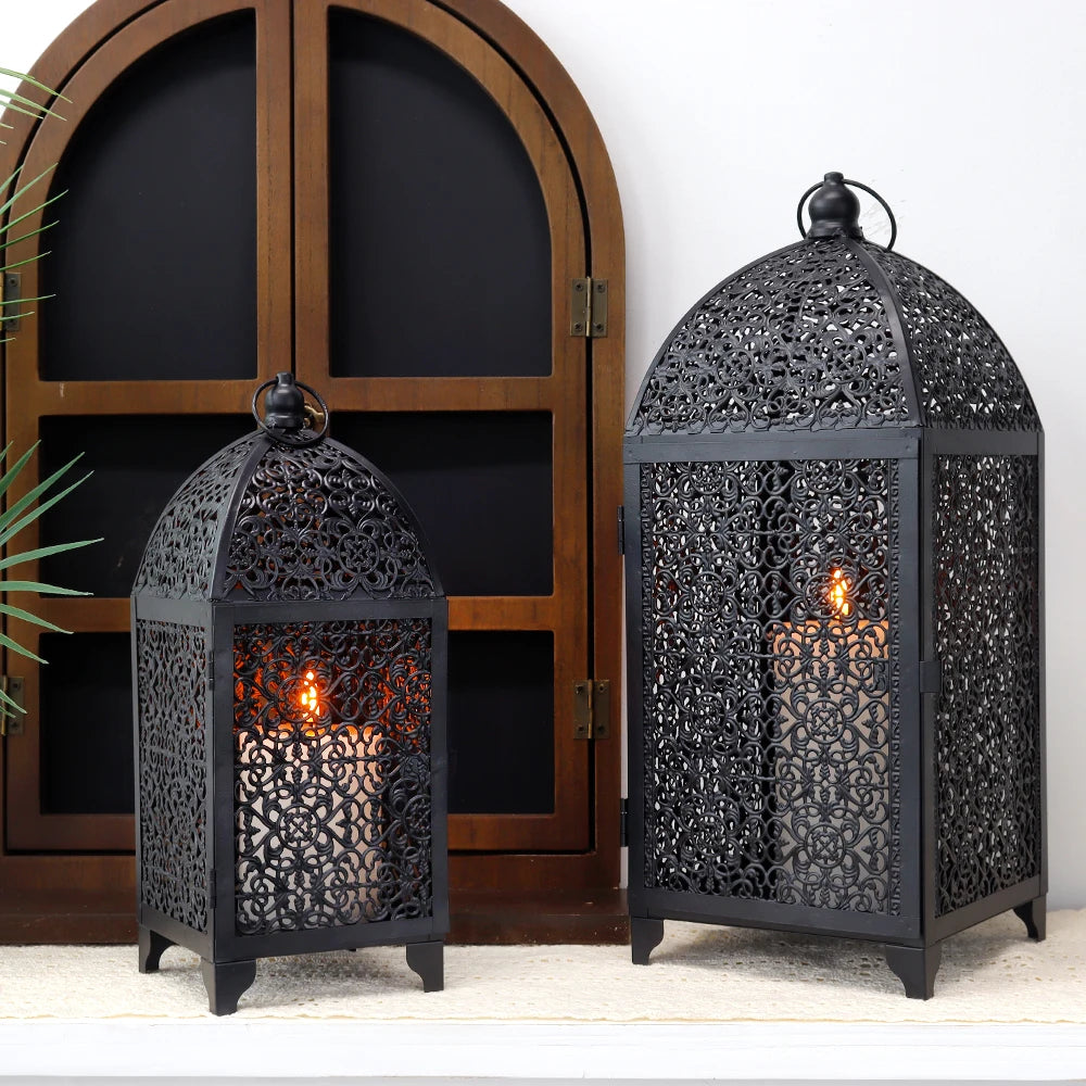 Lanternes noires en métal ajouré de style oriental avec bougies allumées.