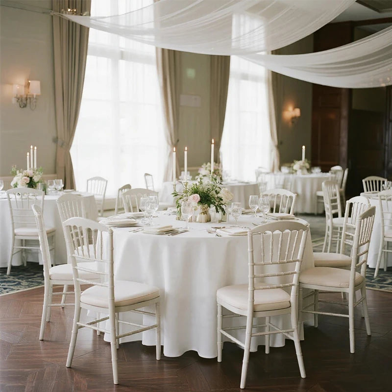 Nappe ronde blanche utilisée dans une salle de réception élégante.