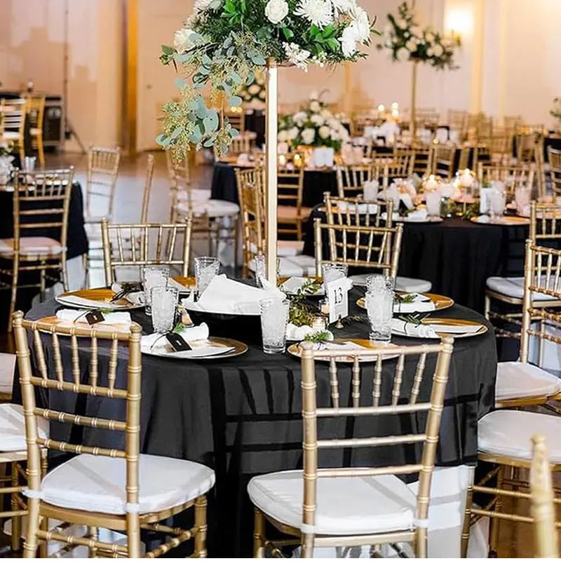 Nappe ronde noire utilisée pour décoration de table lors d’un événement élégant.