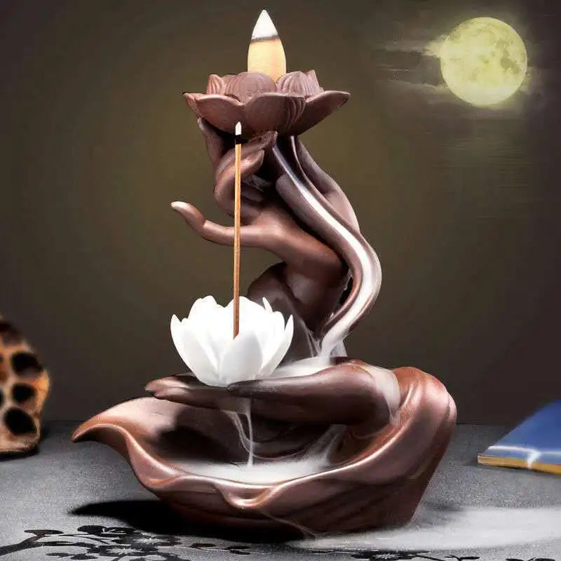 Porte encens lotus avec main sculptée diffusant la fumée dans une ambiance méditative.