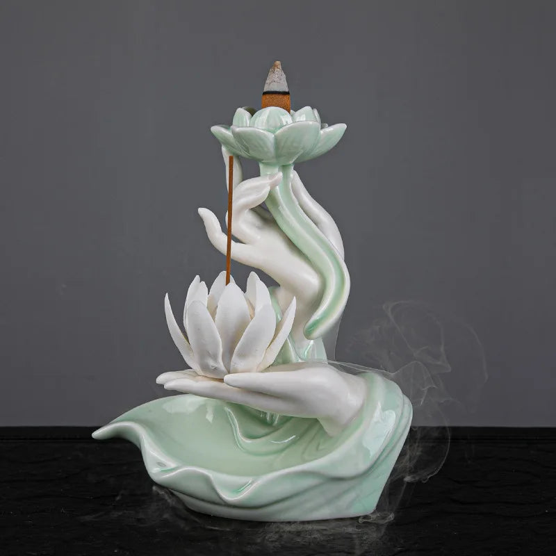 Porte encens lotus avec main sculptée tenant un bâton d’encens et une fleur.