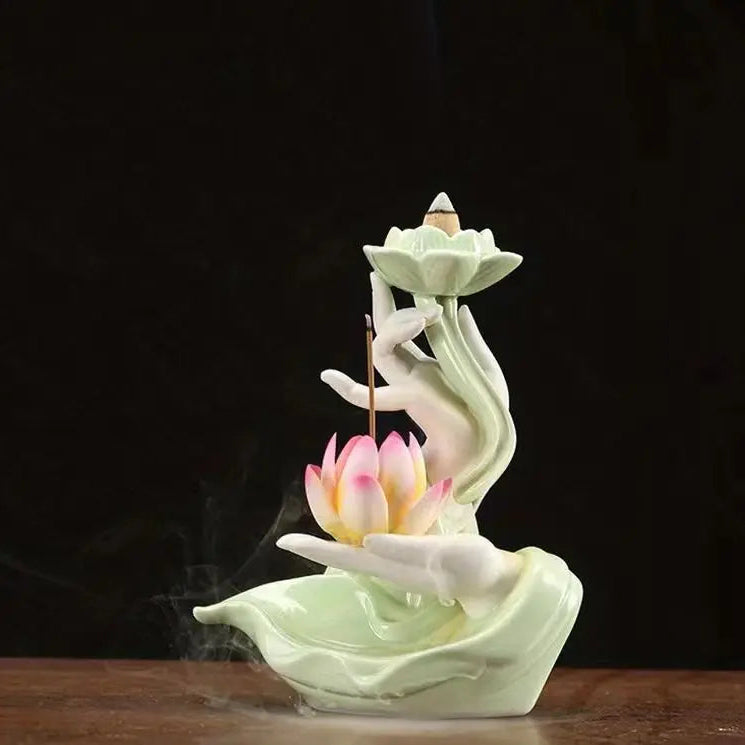 Porte encens lotus en céramique vert clair avec fleur colorée et fumée douce.