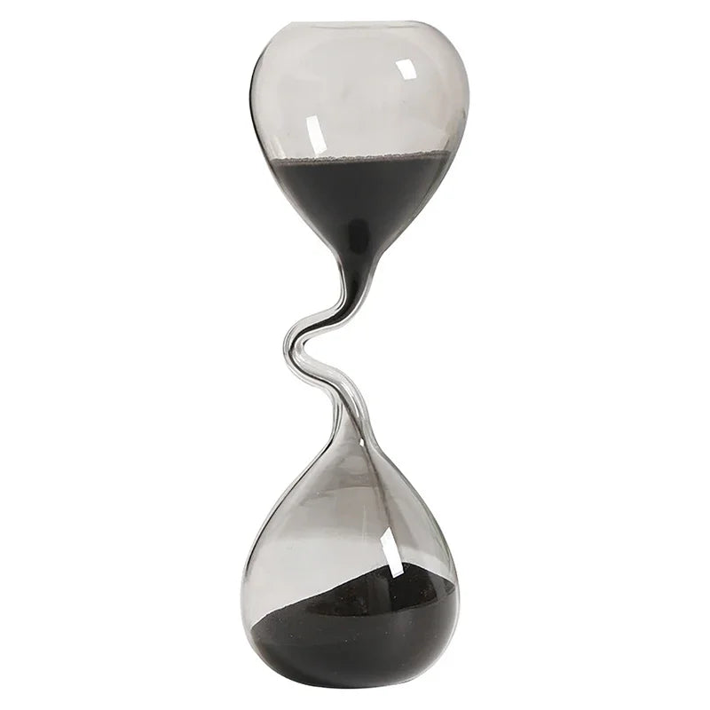 Sablier en verre transparent contenant du sable noir, forme originale et épurée.