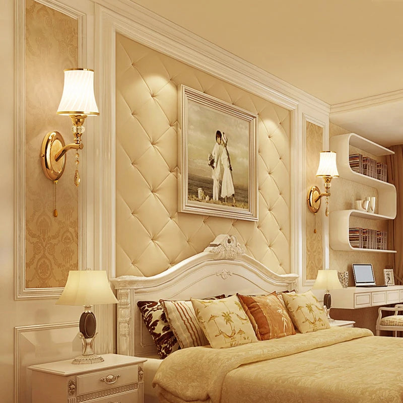 Chambre chic avec deux appliques murales dorées encadrant une tête de lit capitonnée beige, ambiance cosy