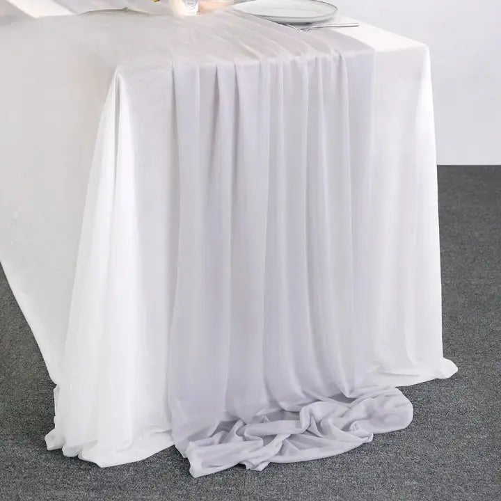 Chemin de table gris clair en voile léger transparent posé sur table blanche pour décoration élégante