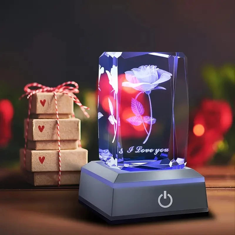 Cristal gravé rose 3D illuminé en bleu, posé près de cadeaux, idée cadeau romantique Saint-Valentin