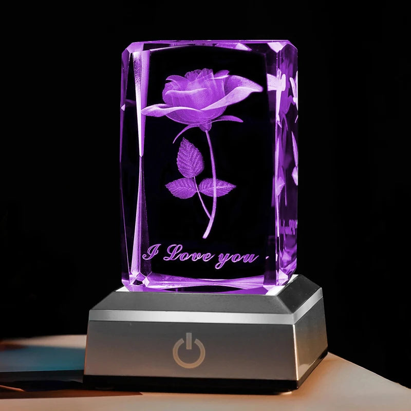 Gros plan sur le bloc de cristal rose gravé en 3D éclairé en violet intense, message I Love You visible