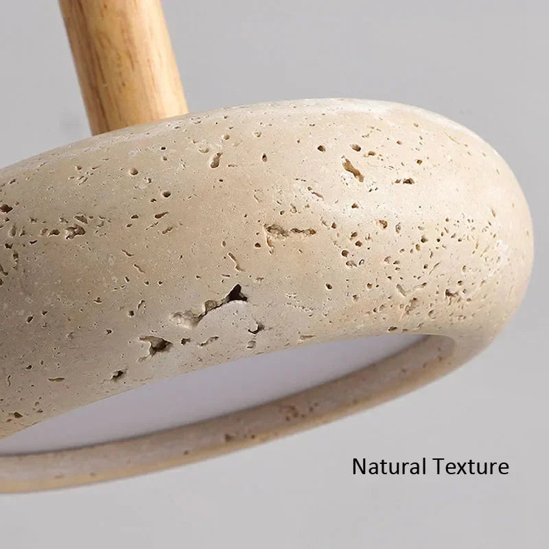 Gros plan sur la texture naturelle en pierre d’un luminaire suspendu.