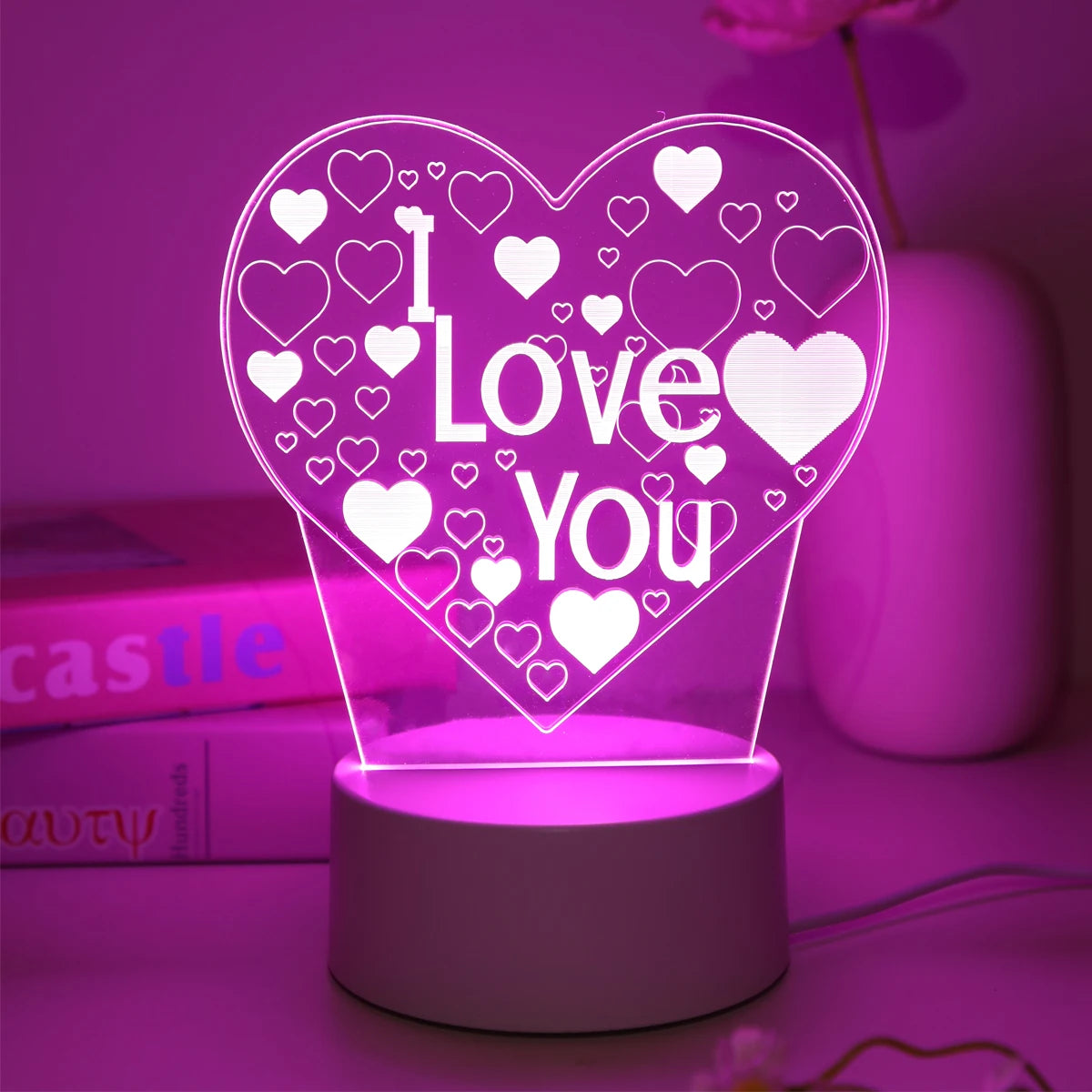 lampe led en forme de coeur i love you avec éclairage rose posée sur un bureau décoration romantique