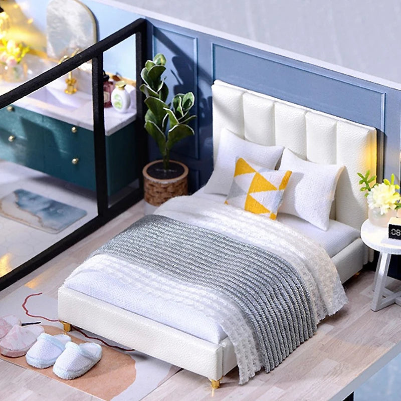 Lit miniature moderne avec coussins décoratifs et table de chevet