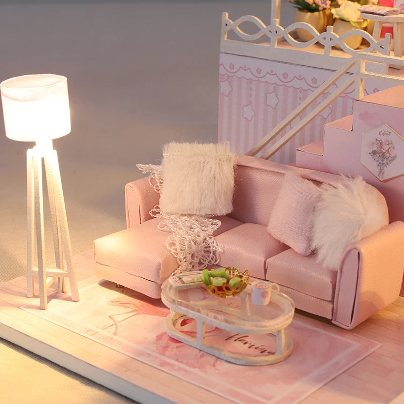 Salon miniature rose avec canapé, lampe sur pied et table basse décorée