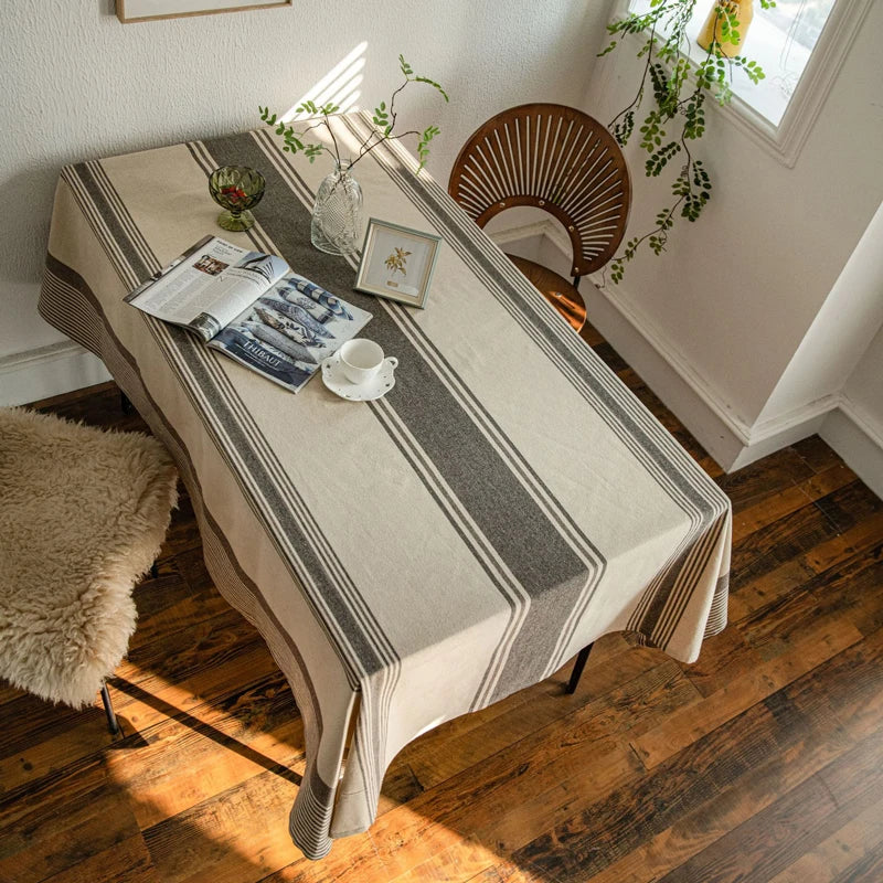 Vue de dessus d’une table recouverte d’une nappe beige à rayures grises dans un intérieur chaleureux