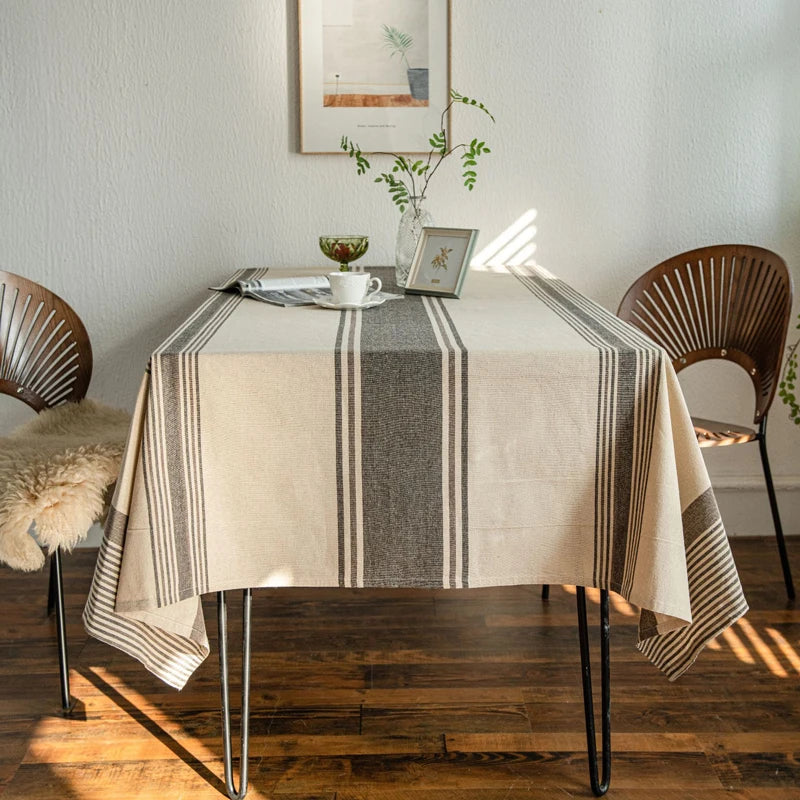 Vue frontale d’une nappe en coton beige à rayures grises sur table de salle à manger moderne