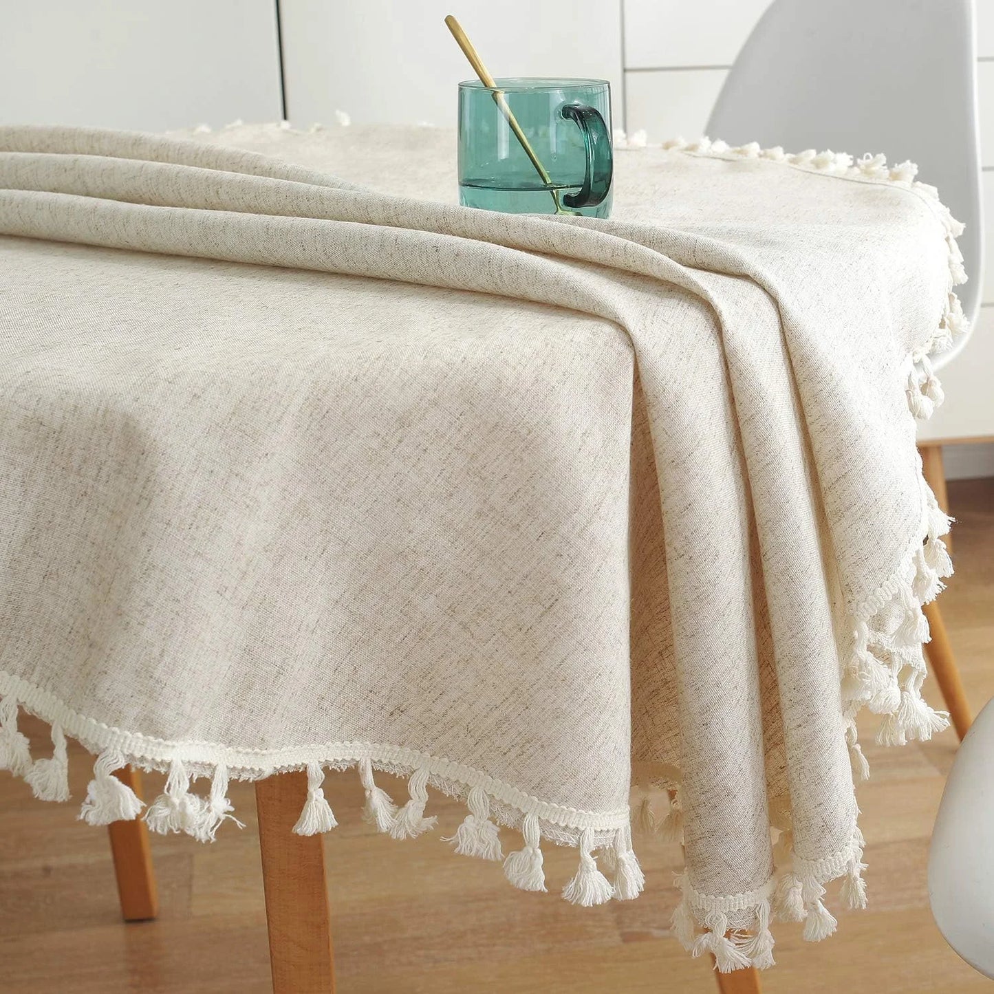Retombée élégante de la nappe en lin beige naturel sur le bord de la table
