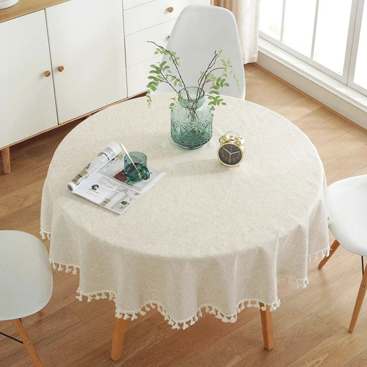 Vue du dessus d’une table ronde habillée d’une nappe en lin beige naturel