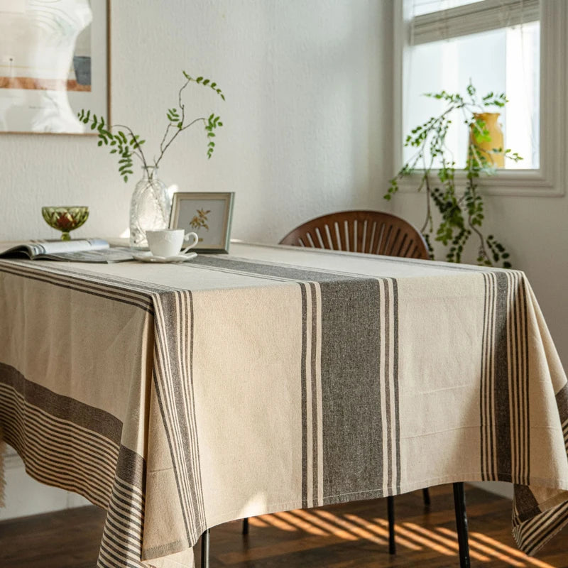 Nappe rayée beige et gris sur table rectangulaire dans une salle à manger lumineuse style naturel