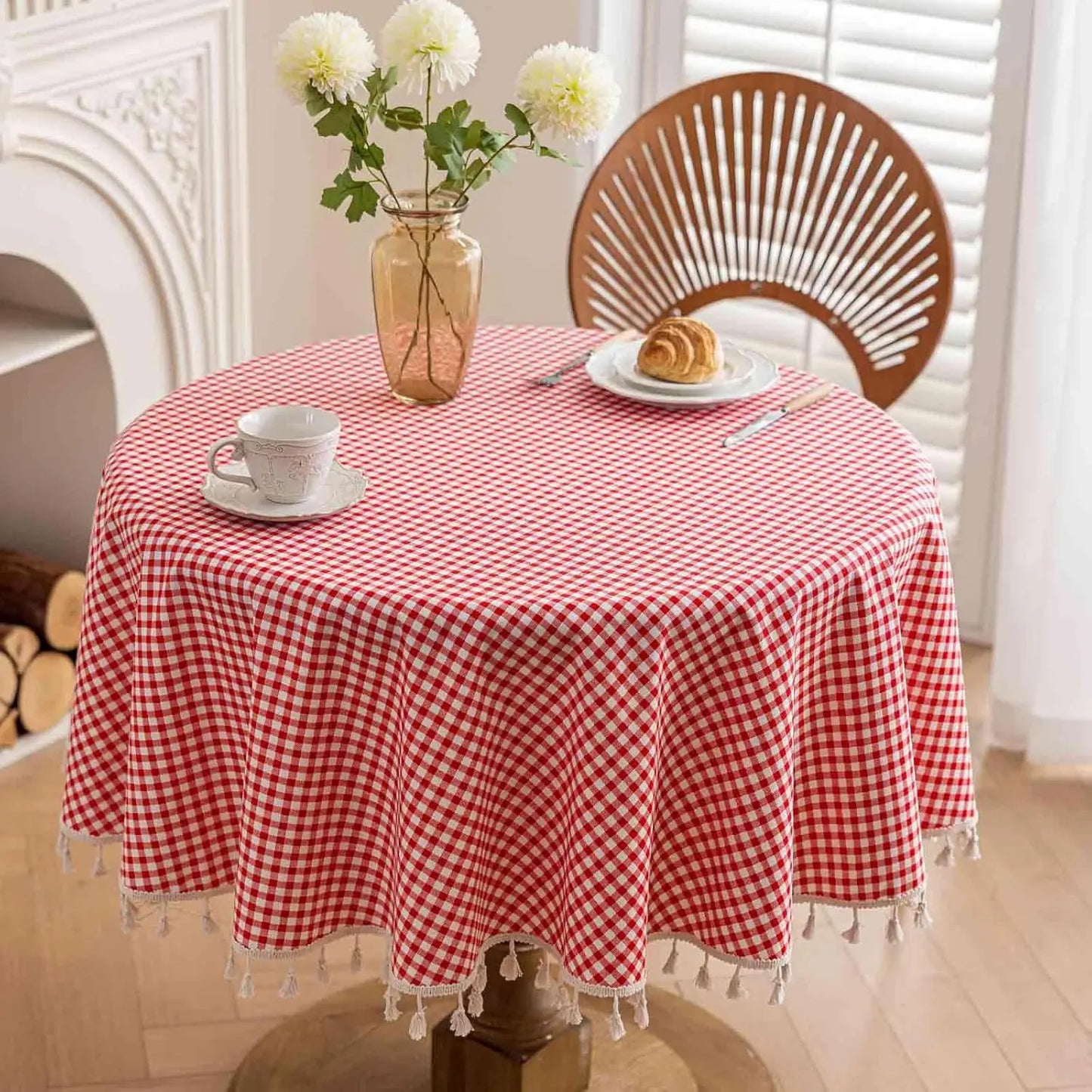 Nappe vichy rouge sur table ronde avec vase et croissant pour ambiance petit déjeuner