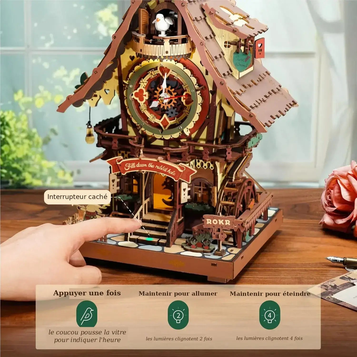 Main activant l'interrupteur caché de l'horloge coucou en bois pour contrôler le chant et l'éclairage intégré