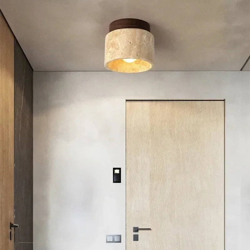 Plafonnier en pierre et bois installé dans un couloir avec porte en bois.
