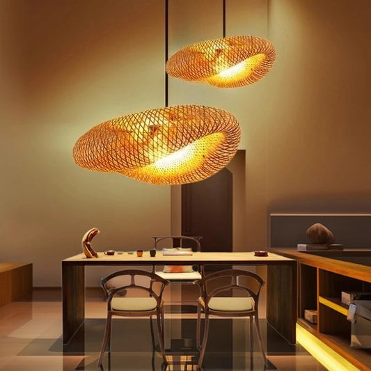 Suspension en bambou naturel diffusant une lumière chaude au-dessus d’une table.